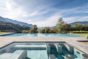 A swimming pool with a view of mountains and trees. - Hotel Hofbrunn (Rifiano)