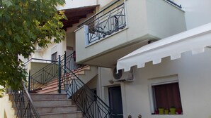 A multi-story building with a staircase leading to the upper floors. - Nikos Apartments (Sithonia)