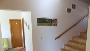 A staircase with a wooden handrail leading to a landing. - Nikos Apartments (Sithonia)