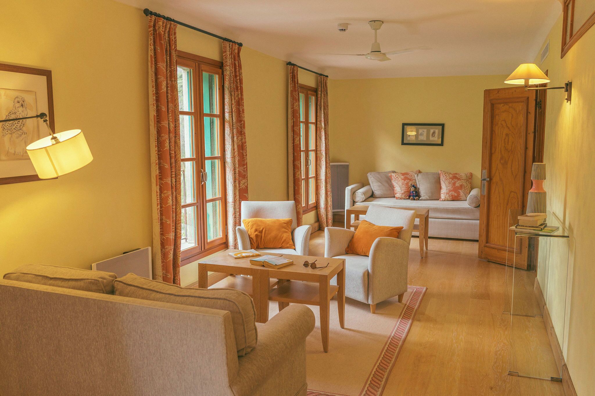 Una sala de estar con un sofá, sillones, una mesa de centro y un televisor.
