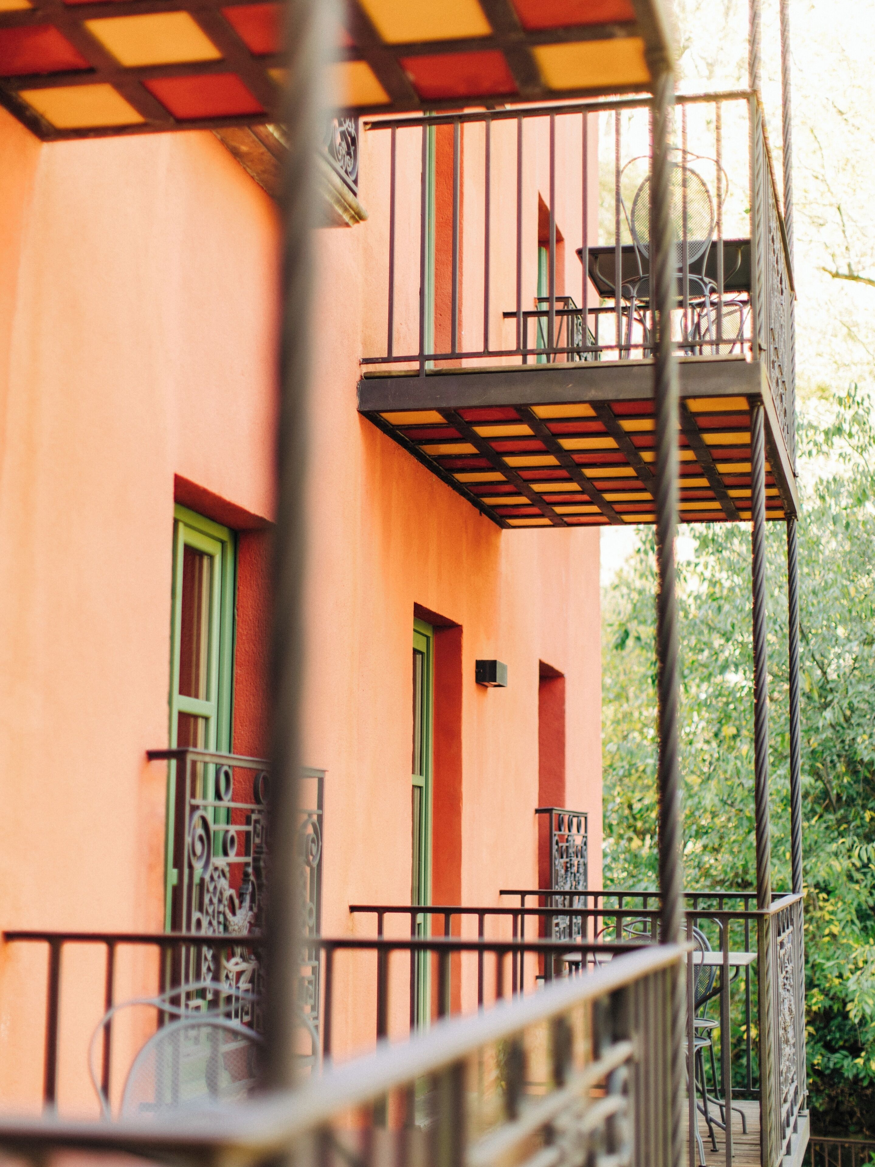 A multi-story building with balconies, a staircase, and outdoor furniture.