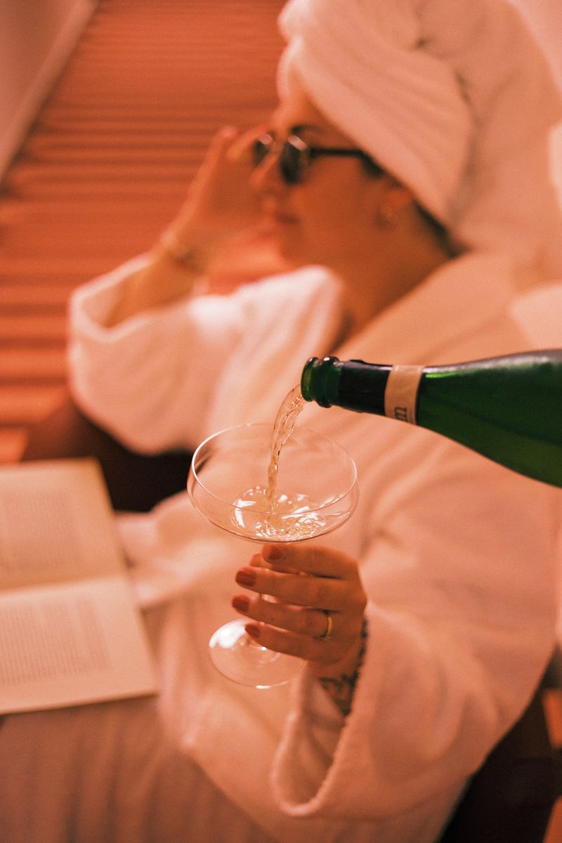 A person pouring a liquid from a bottle into a glass.