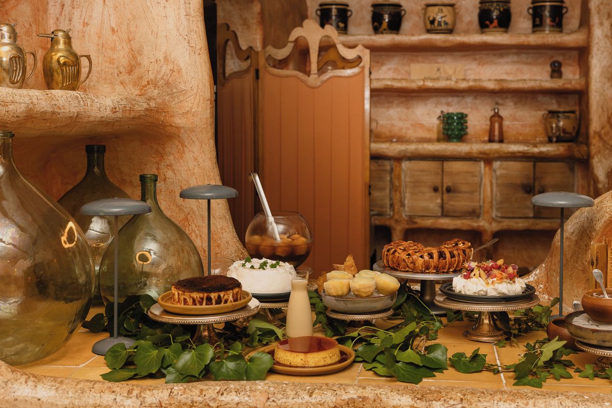 A traditional setting with a stone wall, a wooden door, and shelves with pottery.