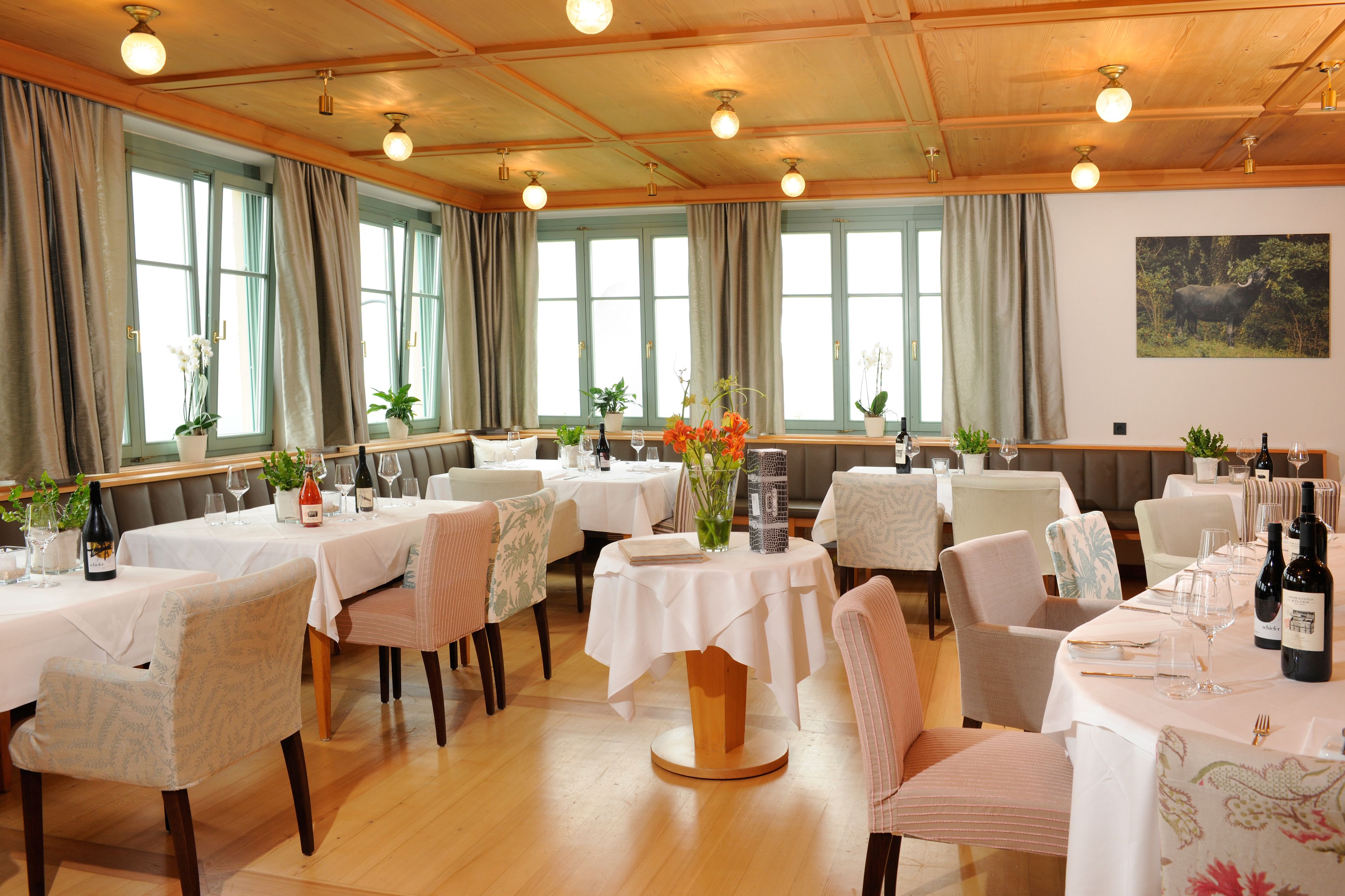 A dining area with multiple tables set for dining, each with chairs and table settings.