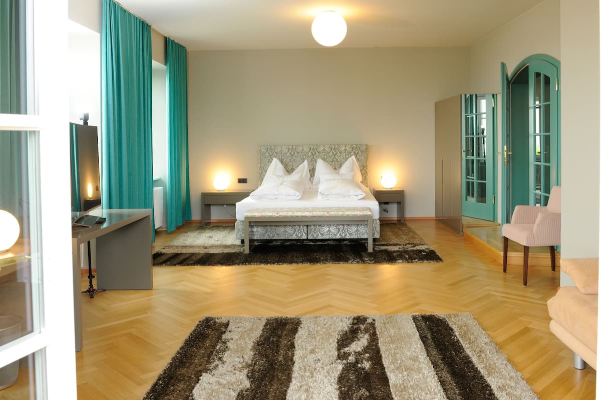 A bedroom with a bed, bedside tables, a desk, a chair, and a wardrobe.