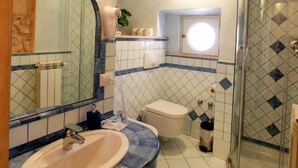 A bathroom with a curved shower, a sink, and a toilet. - Residenza Cardinale (Tropea)