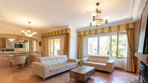 A spacious living area with a sofa set, a coffee table, and a kitchen in the background. - Villa Benimarco by Costa CarpeDiem (Teulada)