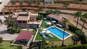 A large house with a swimming pool, multiple lounge chairs, and a well-maintained garden. - Villa Benimarco by Costa CarpeDiem (Teulada)