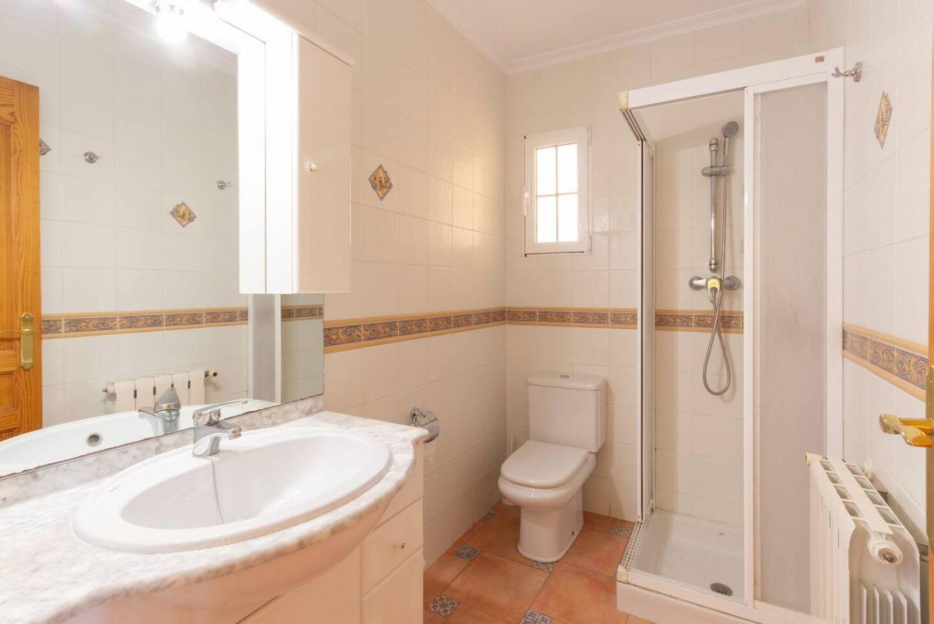 A bathroom with a sink, toilet, and shower.