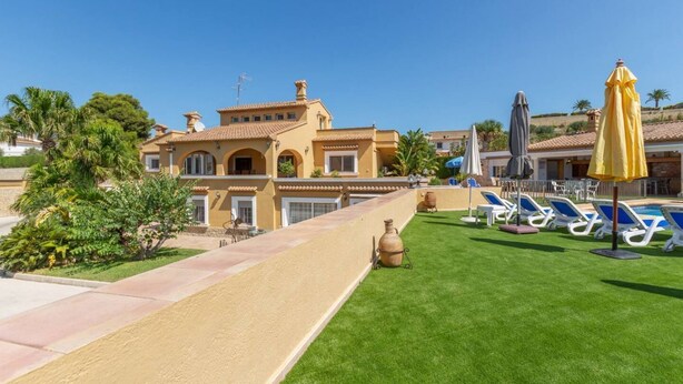 A resort with a pool area, sun loungers, and a large building with a tiled roof. - Villa Benimarco by Costa CarpeDiem (Teulada)
