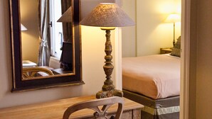 Un bureau en bois, une chaise, un grand miroir et une lampe.