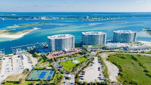Vista aérea de un hotel costero con tres edificios de gran altura, un puerto deportivo y un complejo de deportes.
