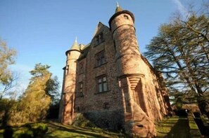 Un château historique en pierre, doté de nombreuses tours et d’une cour centrale.