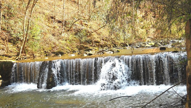 A waterfall in a forested area with clear water flowing over rocks. - SERENITY IN THE MOUNTAINS - Private-view-convenient-unique-hot tub-ev charging (Sevierville)