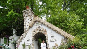 A rustic stone building with a thatched roof labeled "Welcome to Paradise." - SERENITY IN THE MOUNTAINS - Private-view-convenient-unique-hot tub-ev charging (Sevierville)