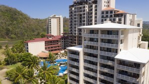 A hotel with multiple floors, balconies, and a pool area.