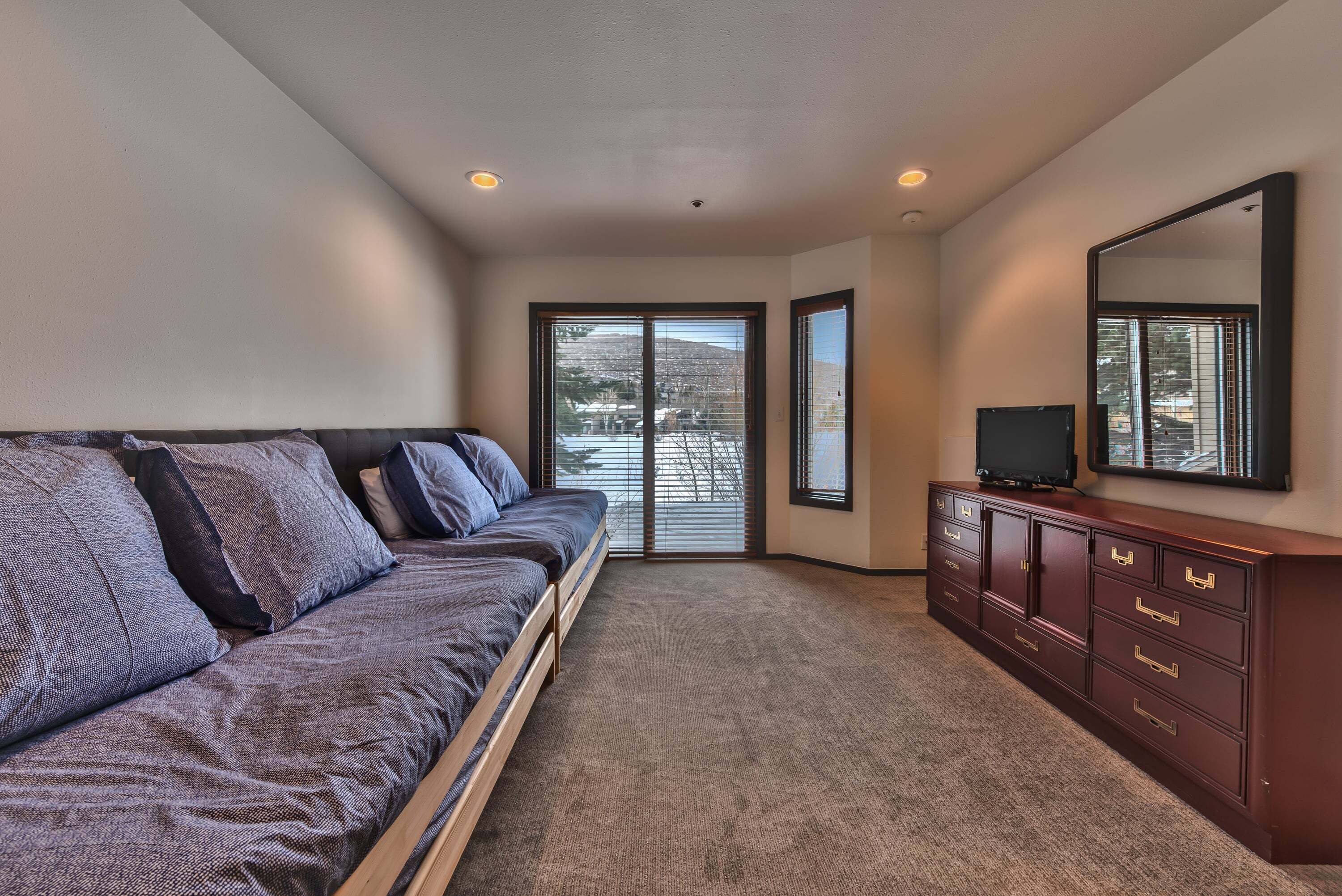 A room with a sofa, a cabinet, and a television.