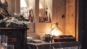 A buffet setup with fruits and beverages, a decorative wall with a 'LOWER' sign, and a statue.