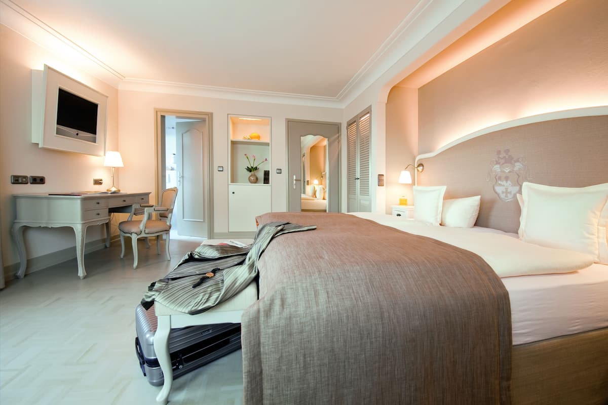Une chambre d’hôtel équipée d’un lit, d’un bureau, d’une chaise et d’un téléviseur.