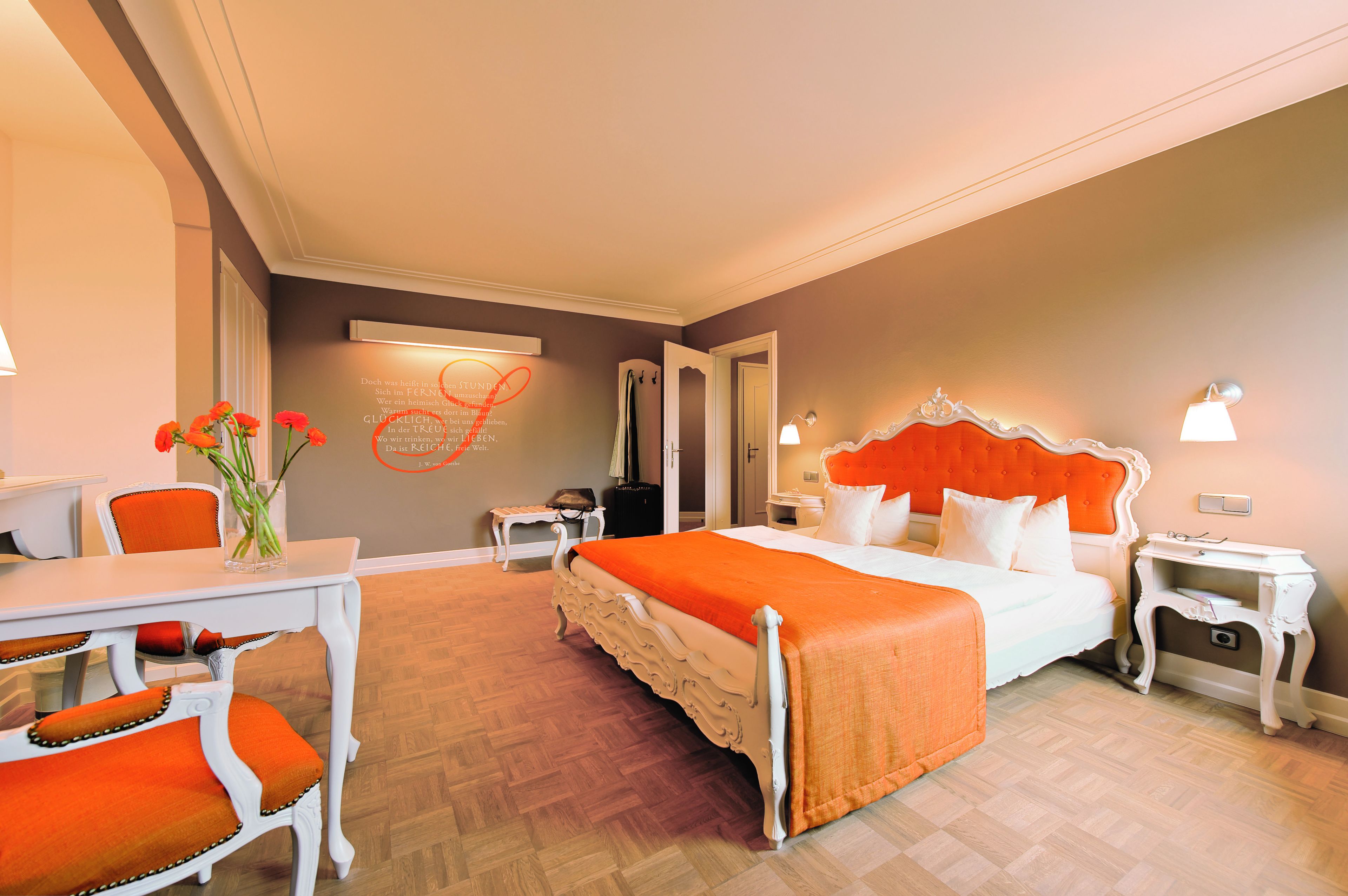 A hotel room with a bed, a desk, and chairs.