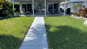 Un patio techado con un camino de hormigón que lleva a un edificio.