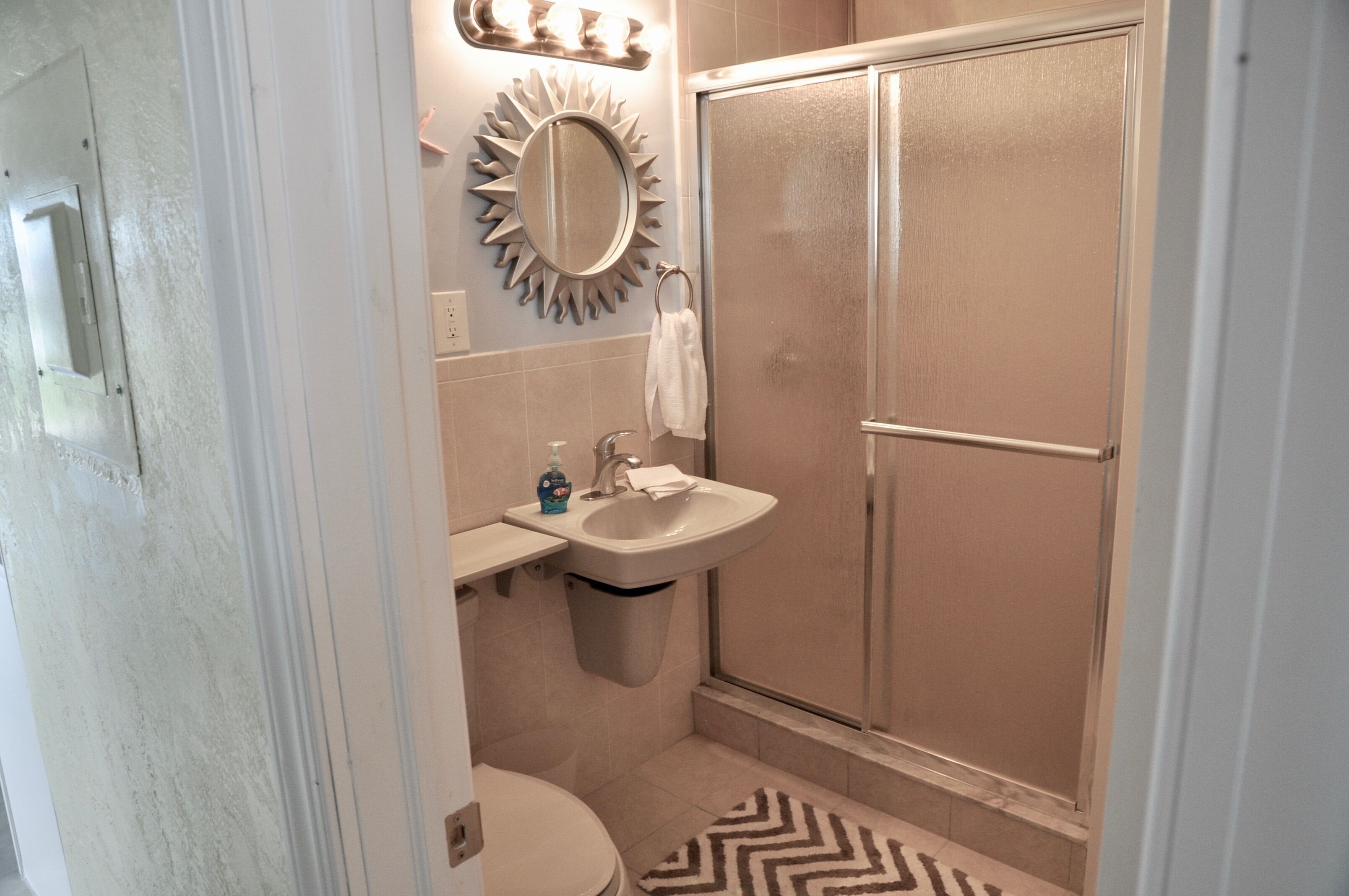 Ein Badezimmer mit Dusche, Waschbecken und Toilette.
