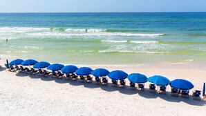 A beach with rows of blue umbrellas and beach chairs facing the ocean. - Last minute discount July 5-11!  Watercolor Camp district 5BR w/ Pool & Spa (Santa Rosa Beach)