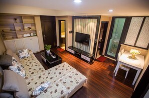 A modern bedroom with a bed, a TV, a small table, and a wardrobe. - Zixinju Aparthotel (Changsha)