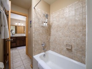 Ein Badezimmer mit Badewanne, Dusche und Fliesen.