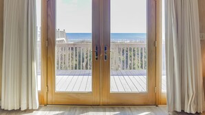 Une pièce dotée d’une grande porte-fenêtre coulissante donnant sur un balcon avec vue sur l’océan.