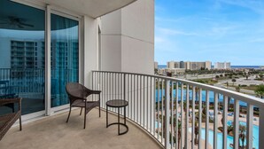 A balcony with a view of a pool and buildings.