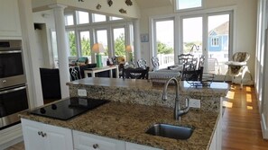 Una cocina con encimeras de granito, un lavamanos de acero inoxidable y un horno empotrado.