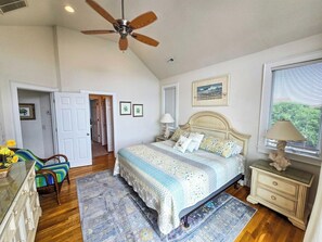 A bedroom with a bed, nightstands, a dresser, a chair, a ceiling fan, and a window with blinds. - Ocean-side 6BR Corolla escape with private pool, hot tub & game room BI-20 (Corolla)