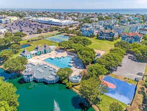 Vista aérea de una zona residencial con piscina, canchas de tenis y un complejo de edificios grande.
