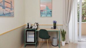 A room with a desk, a chair, a small fridge, a potted plant, and a window with curtains. - Proja Housing Romagnosi 20 (Rome)
