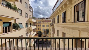 A narrow street between buildings with balconies, a clear sky, and a visible street below. - Proja Housing Romagnosi 20 (Rome)