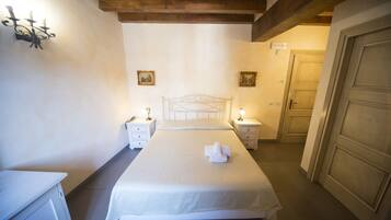 A bedroom with a bed, bedside tables, a wardrobe, and a door.