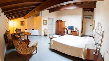 Ein geräumiges Zimmer mit einem großen Bett, Holzmöbeln und einer klassischen Einrichtung.