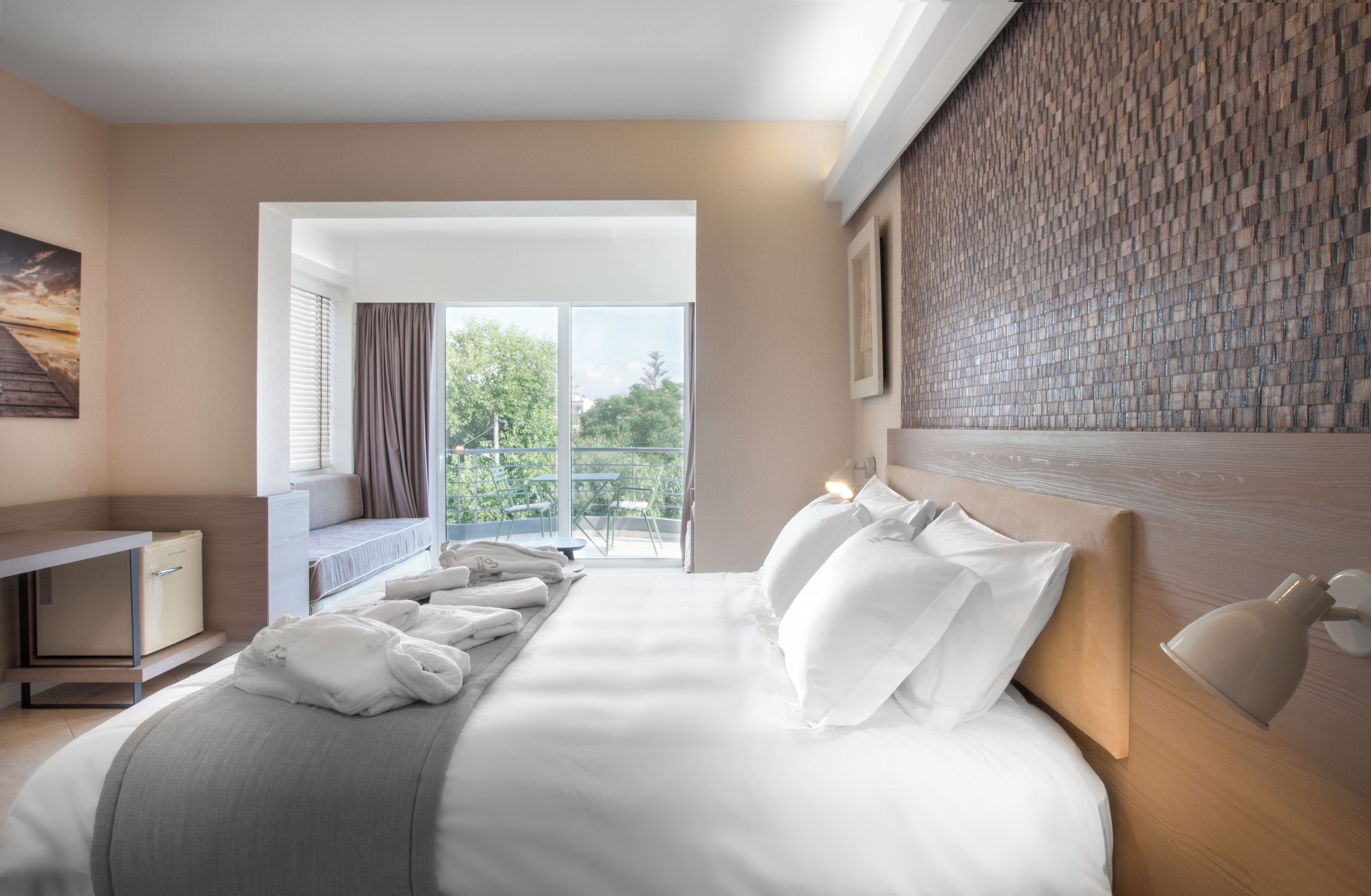 Ein Hotelzimmer mit Bett, Schreibtisch und Blick ins Freie.