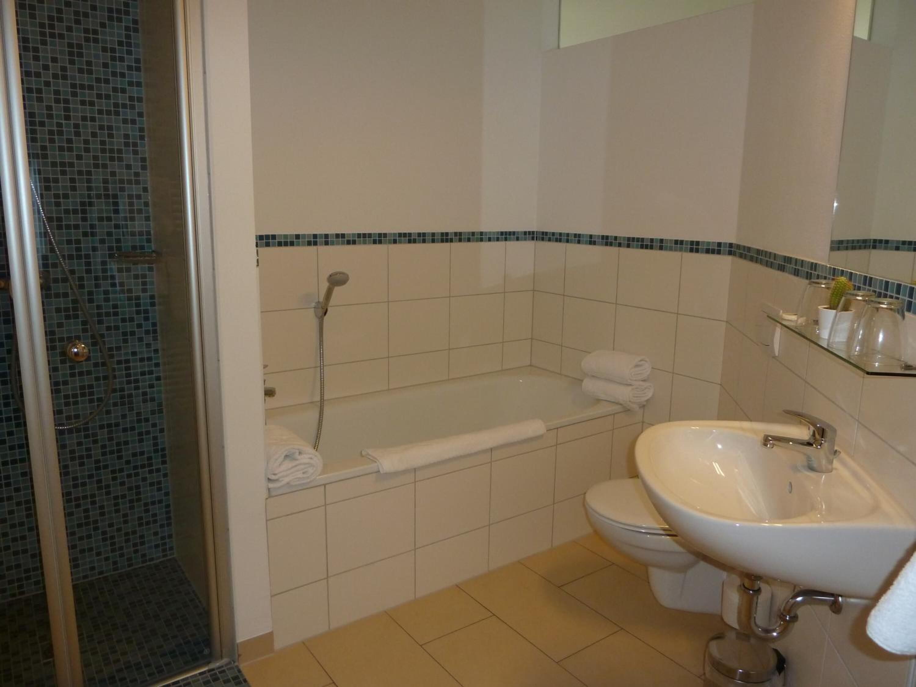 A bathroom with a bathtub, toilet, and sink.