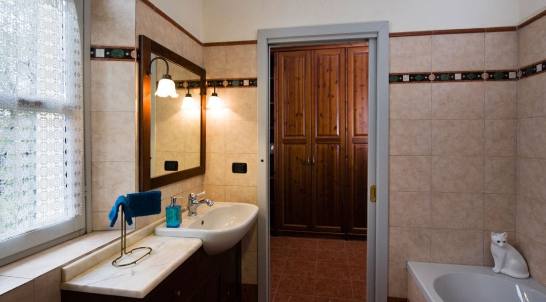 Un baño con lavamanos, espejo y bañera.
