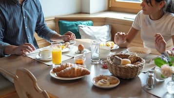 Ein Frühstückstisch mit Croissants, Eiern und Orangensaft.