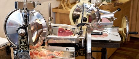 A meat slicer with a wooden background and a counter with various items.