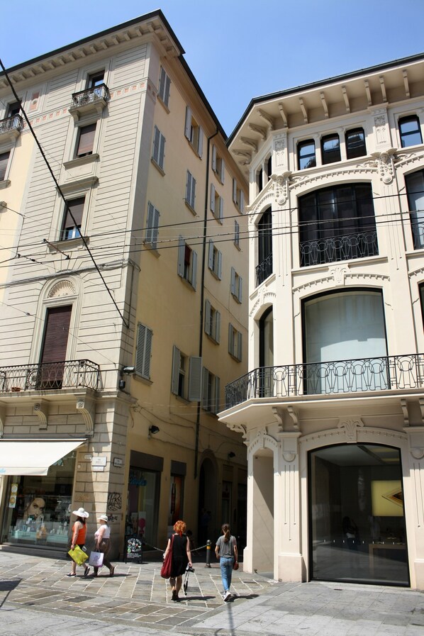 Une rue bordée d’immeubles à l’architecture classique, avec des balcons et de grandes fenêtres.