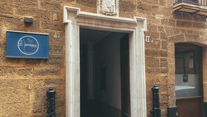 A stone building entrance with a sign for 'APODACA ROOMS'.