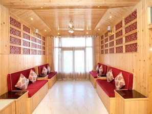 A wooden interior with two wooden benches and a ceiling fan. - OYO 12170 Home Rustic Villa Kasauli (Kasauli)