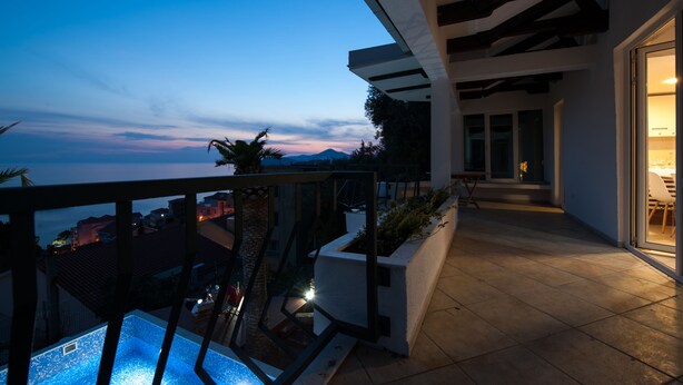 A balcony with a pool, a view of the city, and a modern architectural design.