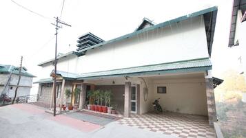 A two-story building with a covered porch and a checkered entrance.