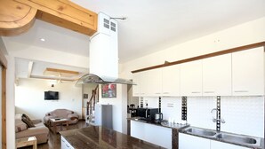 A modern kitchen with white cabinets, a granite countertop, and a built-in stove. - OYO 12185 Home Wayside Villa 3BHK Apartment Kasauli (Kasauli)
