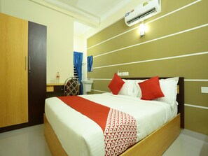 Een hotelkamer met een bed, een kledingkast, een badkamer en een airconditioning.